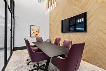 A conference room with a long table and chairs.